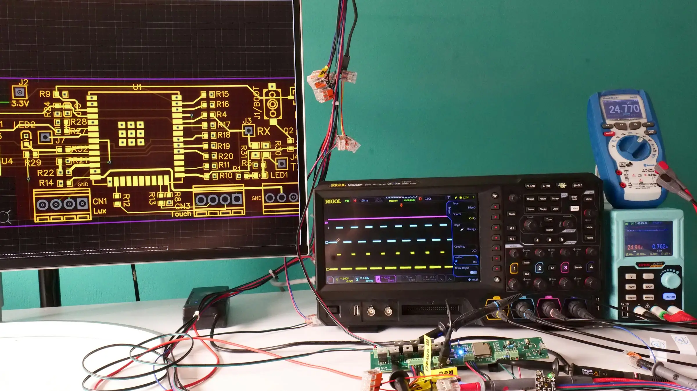 Electronics test bench with an oscilloscope, multimeter and circuit board
